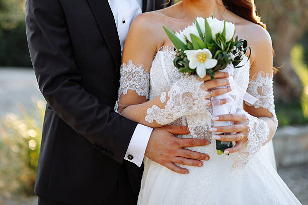 Happy bride and groom on their wedding hugging. Closeup Bride holding a bouquet
